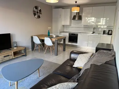 a living room with a couch and a table and a kitchen at Alice in Cannes