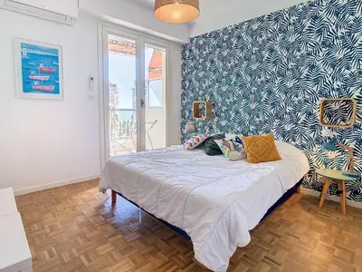a bedroom with a bed with a blue and white wall at 1 bedroom Velasquez, 5 mins from Croisette 244 Cannes Riviera in Cannes