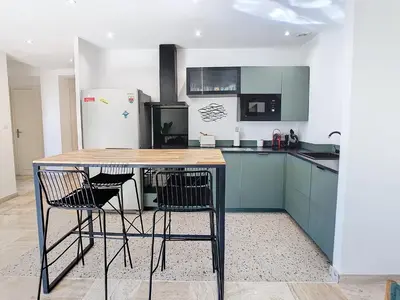 a kitchen with blue cabinets and a table with chairs at 1 bedroom Velasquez, 5 mins from Croisette 244 Cannes Riviera in Cannes