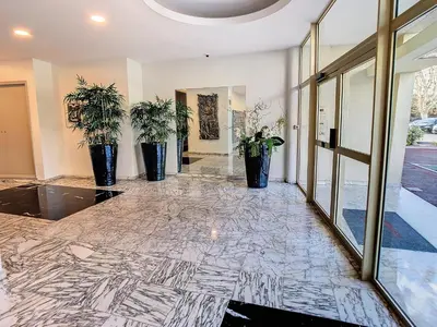 a lobby with three potted plants on a marble floor at 1 bedroom Velasquez, 5 mins from Croisette 244 Cannes Riviera in Cannes