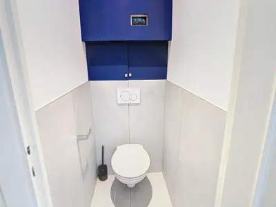 a small bathroom with a toilet and blue cabinets at 1 bedroom Velasquez, 5 mins from Croisette 244 Cannes Riviera in Cannes