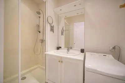 a white bathroom with a sink and a shower at FRGK 