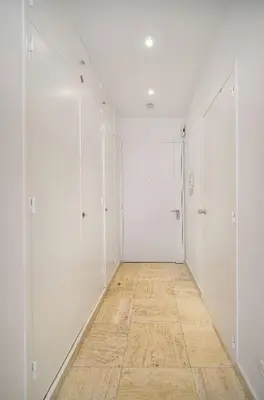 an empty hallway with white walls and a wooden floor at FRGK 