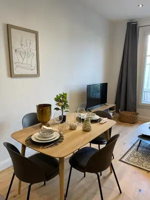 a dining room table and chairs in a living room at Le Borniol by Connexion in Cannes