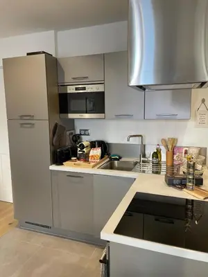 a kitchen with a sink and a stainless steel refrigerator at Le Borniol by Connexion in Cannes