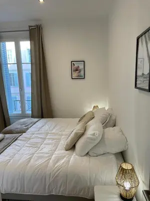 a bedroom with a white bed with pillows on it at Le Borniol by Connexion in Cannes