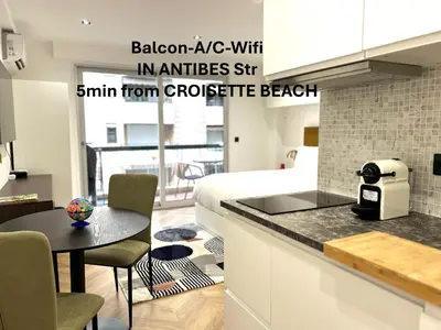 a kitchen and living room with a bed and a table at Moderne Studio BALCON, rue D'ANTIBES- HYPER CENTRE A0B191 in Cannes