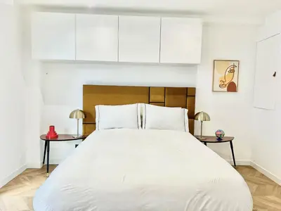 a bedroom with a large white bed with two tables at Moderne Studio BALCON, rue D'ANTIBES- HYPER CENTRE A0B191 in Cannes
