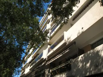 a tall white building with trees in front of it at Superbe Studio in Cannes 450m sea & parking in Cannes