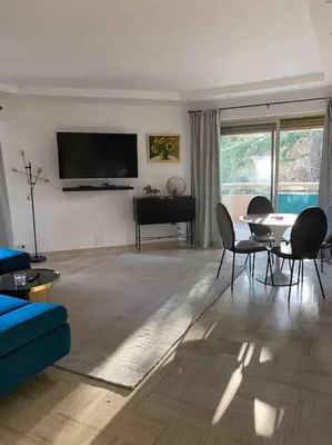 a living room with a couch and a table with chairs at 2 bedroom apartament close to the beach in Cannes