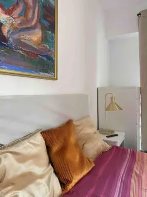 a bedroom with a bed with a painting on the wall at 2 bedroom apartament close to the beach in Cannes