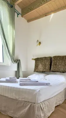 a bed with white sheets and pillows on it at L'échelle Rouge in Cannes