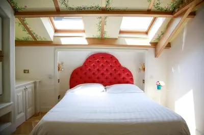 a red bed with a red headboard in a room at L'échelle Rouge in Cannes