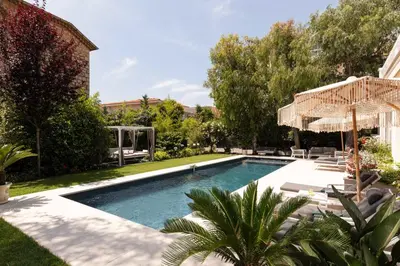 a swimming pool in a yard with chairs and an umbrella at Luxueuse Villa 7 chambres avec piscine - Cannes in Cannes