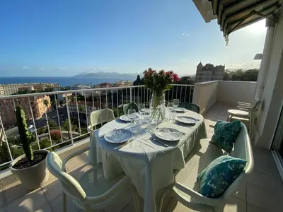 a table on a balcony with a view of the city at Vue mer à couper le souffle - nouveau entièrement rénové in Cannes