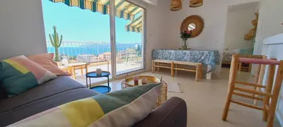 a living room with a couch and a large window at Vue mer à couper le souffle - nouveau entièrement rénové in Cannes