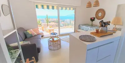 a kitchen and living room with a view of the ocean at Vue mer à couper le souffle - nouveau entièrement rénové in Cannes