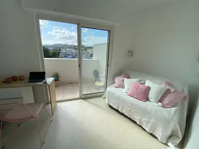a bedroom with a bed and a desk and a window at Vue mer à couper le souffle - nouveau entièrement rénové in Cannes