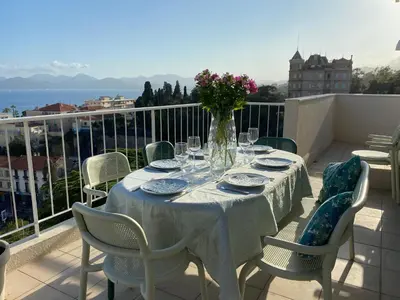 a table with a vase of flowers on a balcony at Vue mer à couper le souffle - nouveau entièrement rénové in Cannes