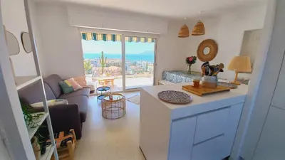 a kitchen and living room with a view of the ocean at Vue mer à couper le souffle - nouveau entièrement rénové in Cannes