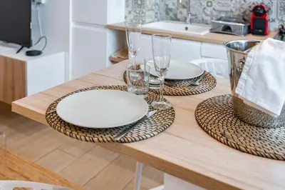 a table with two white plates and glasses on it at Centre - 10mn Palais - Plages - Croisette - AT in Cannes