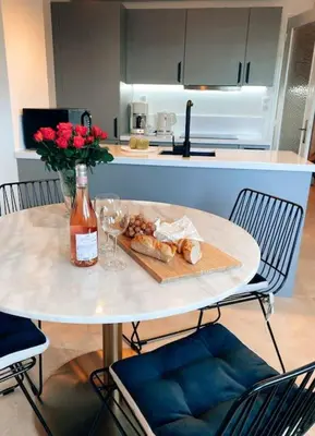 a table with a plate of food and a bottle and glasses at 2 bedroom apartment in Cannes near the beach in Cannes
