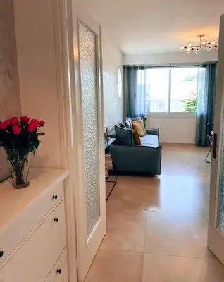 a living room with a couch and a vase of roses at 2 bedroom apartment in Cannes near the beach in Cannes