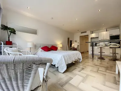 a bedroom with a white bed and a kitchen at Gray d Albion THI235 in Cannes