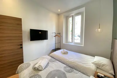 a bedroom with two beds and a flat screen tv at New apartment in Forville with balcony in Cannes
