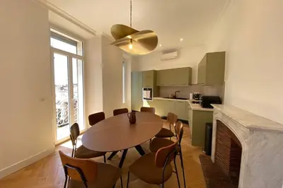 a kitchen and dining room with a table and chairs at New apartment in Forville with balcony in Cannes