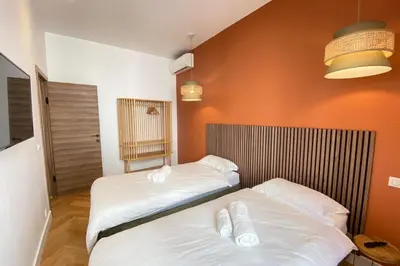 two beds in a room with orange walls at New apartment in Forville with balcony in Cannes