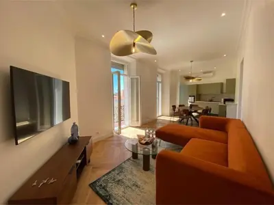 a living room with a orange couch and a television at New apartment in Forville with balcony in Cannes