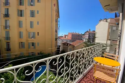 a balcony with a yellow chair and buildings at New apartment in Forville with balcony in Cannes
