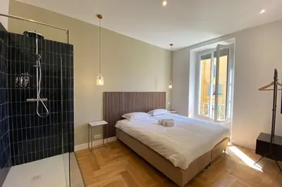 a bedroom with a large bed and a shower at New apartment in Forville with balcony in Cannes