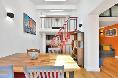 a dining room with a table and chairs and a staircase at LE CHARMANT sublime Maison de Ville dans le Suquet au calme in Cannes