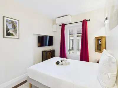 a bedroom with a white bed and red curtains at LE CHARMANT sublime Maison de Ville dans le Suquet au calme in Cannes