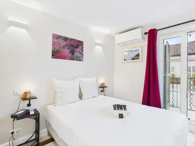 a white bedroom with a bed and a window at LE CHARMANT sublime Maison de Ville dans le Suquet au calme in Cannes