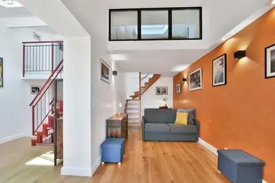 a living room with a couch and stairs at LE CHARMANT sublime Maison de Ville dans le Suquet au calme in Cannes