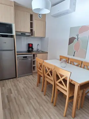 a kitchen and dining room with a table and chairs at 2 pièces climatisé dans résidence avec piscine in Cannes