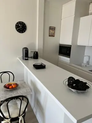 a white kitchen with a counter with a bowl of fruit at Cannes, Croisette, Palais Miramar in Cannes