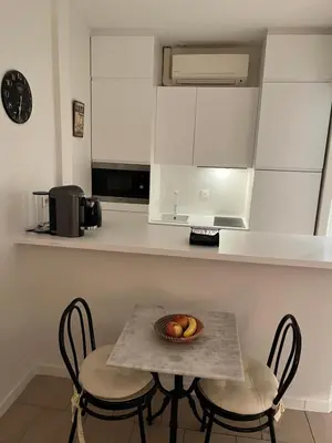 a kitchen with a table with a bowl of fruit on it at Cannes, Croisette, Palais Miramar in Cannes