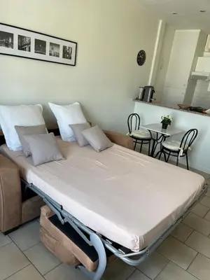 a large bed in a room with chairs and a table at Cannes, Croisette, Palais Miramar in Cannes