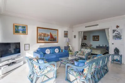 a living room with a blue couch and chairs at Appartement Miramar Cannes Croisette in Cannes