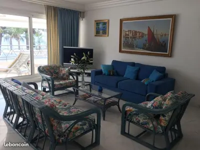 a living room with a blue couch and chairs at Appartement Miramar Cannes Croisette in Cannes