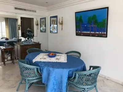 a dining room with a blue table and chairs at Appartement Miramar Cannes Croisette in Cannes