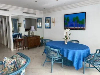 a dining room with a blue table and chairs at Appartement Miramar Cannes Croisette in Cannes
