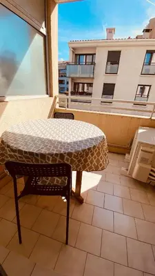 a table and chair on a balcony with a view of a building at Cosy 3pièces à 5min de la plage in Cannes