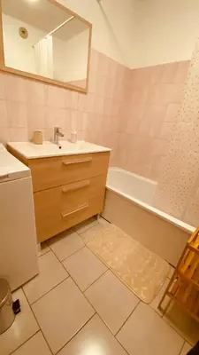 a bathroom with a sink and a tub and a mirror at Cosy 3pièces à 5min de la plage in Cannes