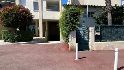 a parking lot with two poles in front of a building at Cosy 3pièces à 5min de la plage in Cannes