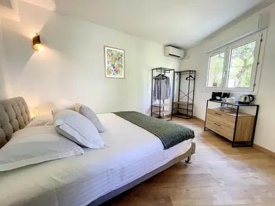 a bedroom with a bed and a dresser and a window at Appartement cosy au centre de Cannes in Cannes